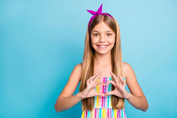 Portrét pozitivní veselý dítě dívka, aby srdce prst tvar show milenec znamení pocity nosit dobrý vzhled světlé oblečení izolované přes modré barvy pozadí — Stock fotografie