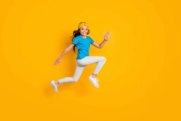 Profilo completo del corpo foto di divertente signorina saltando alto buon umore allegro jogging gara usura casual blu t-shirt fascia pantaloni scarpe isolato colore giallo sfondo — Foto Stock