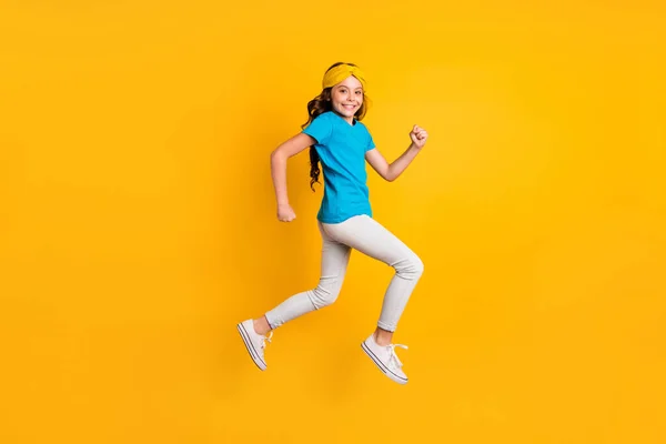 Full length profile photo of funny little lady walking down street jumping high good mood wear casual blue t-shirt headband παντελόνι παπούτσια — Φωτογραφία Αρχείου