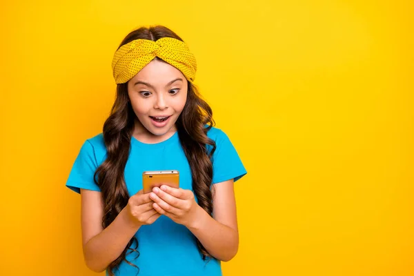 Foto da bela senhora modelo segurar as mãos do telefone conversando amigos quarentena tempo ficar em casa ler notícias boca aberta desgaste casual azul t-shirt headband isolado cor amarela fundo — Fotografia de Stock