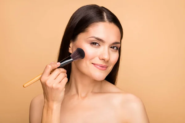 Nahaufnahme Foto von reifen lateinischen nackte Dame Modell im Badezimmer hält Rouge Pinsel Anwendung Grundton für Nacht Make-up isoliert beige pastellfarbenen Hintergrund — Stockfoto