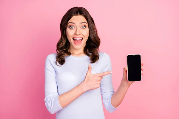 Foto av vacker dam hålla telefon rikta finger pekskärm råda cool förnya gränssnittet modell försäljning pris öppen mun slitage casual vit skjorta isolerad pastell rosa färg bakgrund — Stockfoto