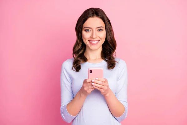 Foto van mooie aantrekkelijke dame krullend kapsel houden telefoon online freelance werk quarantaine thuisblijven lees nieuws dragen casual witte trui geïsoleerde pastel roze kleur achtergrond — Stockfoto