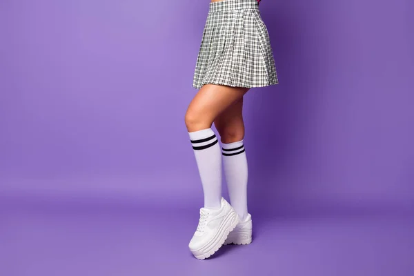 Cropped profile photo of lady showing cool stylish clothes outfit fit slim legs wear short plaid skirt long knee socks white shoes isolated pastel purple color background