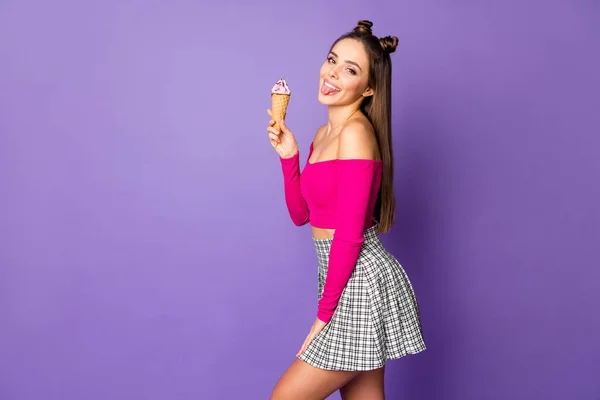 Profile photo of funny lady two pretty buns stick tongue out mouth eat vanilla ice cream wear pink off-shoulders cropped top plaid mini skirt isolated pastel purple color background — Stock Photo, Image