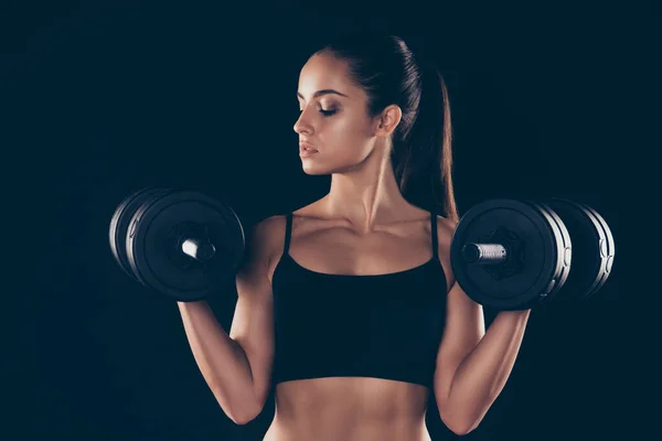 Close up photo of lovely woman hold hand barbells look feel focus hair brunetka fryzura kucyk izolowane na czarnym tle — Zdjęcie stockowe