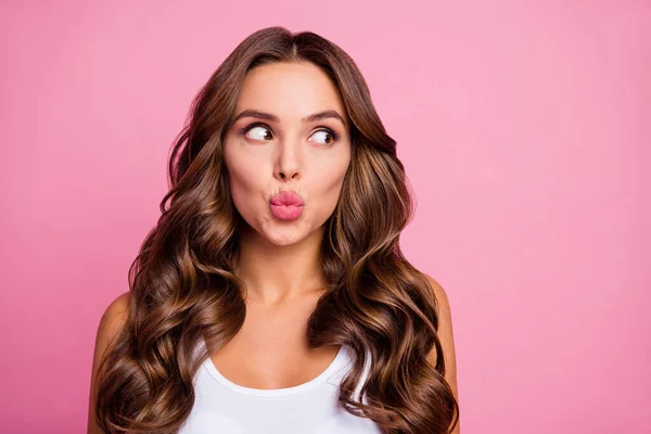 Närbild foto av ganska roligt lockigt dam galen ansiktsuttryck skicka luft kyssar ser intresserad sida tomt utrymme bära vit casual singlet isolerad ljus rosa färg bakgrund — Stockfoto