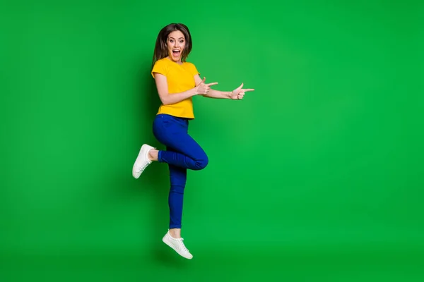 Longitud completa tamaño del cuerpo vista de ella ella agradable atractivo bastante sorprendido alegre alegre chica saltando mostrando espacio de copia anuncio consejos de anuncios aislado brillante brillo vivo vibrante color verde fondo — Foto de Stock