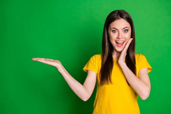 Retrato de ella ella bonita atractiva encantadora alegre sorprendido alegre alegre recta de pelo chica sosteniendo en la palma copia espacio novedad nuevo aislado en brillante brillo vivo vibrante color verde fondo —  Fotos de Stock