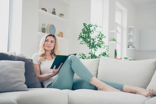 Profil foto av hemmafru dam avkopplande liggande bekväm soffa stanna hemma karantän tid läsa bok drömmare föreställa sig själv huvudsakliga hjälte karaktär vardagsrum inomhus — Stockfoto