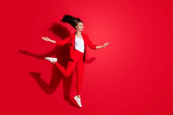 Full length profile photo of attractive worker lady having fun jumping high up good mood holiday having fun wear blazer κοστούμι παντελόνι παπούτσια απομονωμένο έντονο κόκκινο χρώμα φόντο — Φωτογραφία Αρχείου