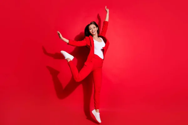 Teljes hosszúságú fotó vonzó vicces hölgy sikeres munkás szórakozás ugrás magas jó hangulat örvendetes viselet blézer ruha nadrág lábbeli elszigetelt élénk piros háttér — Stock Fotó