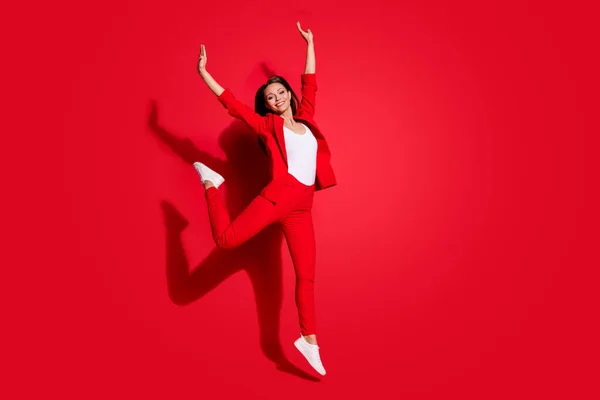 Teljes méretű fotó vonzó vicces hölgy sikeres munkás szórakozás ugrás magas jó hangulat örvendetes viselet blézer ruha nadrág lábbeli elszigetelt élénk piros színű háttér — Stock Fotó