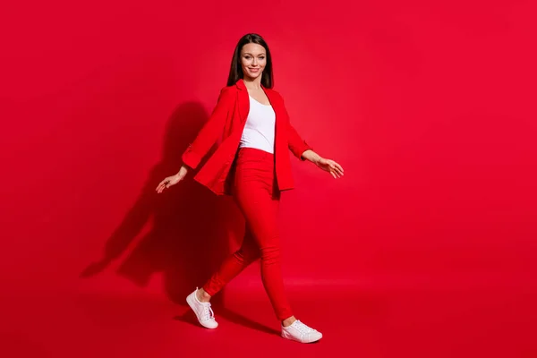 Foto de perfil de longitud completa de hermoso negocio exitosa dama paseo conferencia seminario reunión desgaste lujoso oficina chaqueta pantalones traje camisa blanca calzado aislado color rojo fondo — Foto de Stock