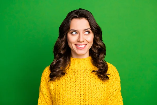 Photo de jolie dame positive joyeuse expression faciale dents souriant bonne humeur regarder côté vide espace porter jaune tricot pull isolé vert vif fond de couleur — Photo