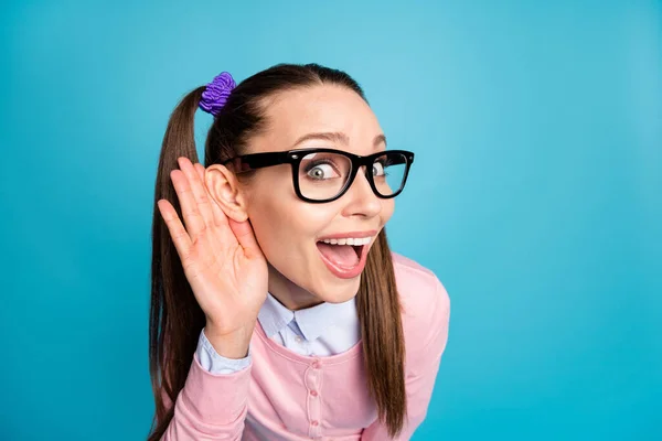 De cerca la foto de asombrado divertido funky adolescente estudiante de la universidad de la mano de la oreja escuchar increíbles rumores usan jersey camisa rosa aislado sobre fondo de color azul — Foto de Stock