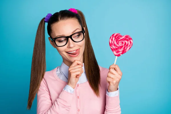 Close-up portrait of her she nice attractive pretty girlish funky cheerful cheery college girl holding in hand candy licking lip isolated over bright vivid shine vibrant blue color background — Stock Photo, Image