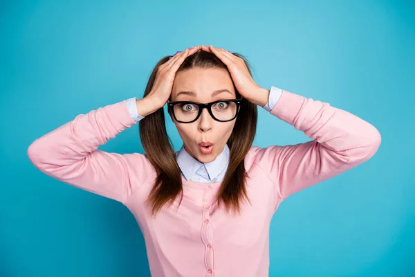 Portret van verbaasd schoolmeisje onder de indruk academisch examen schema aanraking gezicht handen dragen pastel trui geïsoleerd over blauwe kleur achtergrond — Stockfoto
