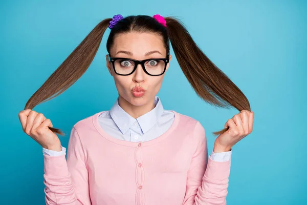 Portrait of carefree playful girl college student touch ponytails send air kiss wear pastel sweater isolated over blue color background — Stock Photo, Image