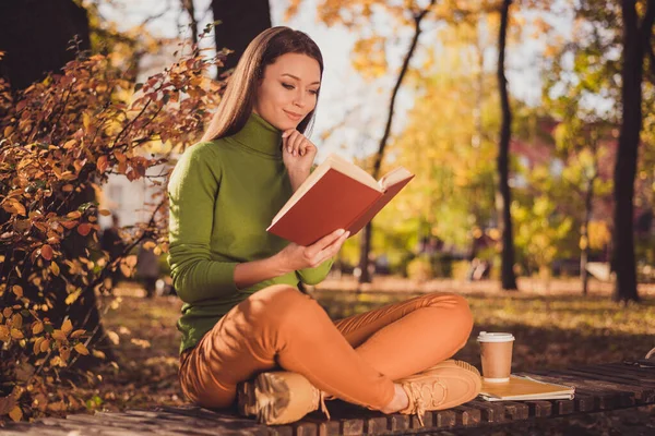 Foto di bella signora intelligente affascinante venire autunno parco leggere romantico romanzo sedersi panca tra gli alberi incrociato gambe mano mento pensare indossare verde dolcevita arancione pantaloni scarpe da ginnastica all'aperto — Foto Stock