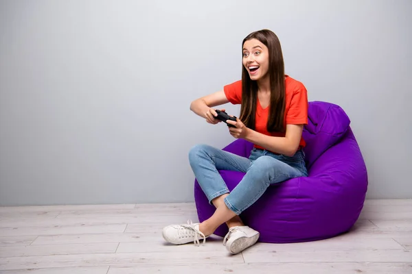 Retrato dela ela agradável atraente linda menina alegre winsome alegre sentado na cadeira saco jogando jogo online se divertindo no quarto luz cinza parede de cor pastel — Fotografia de Stock