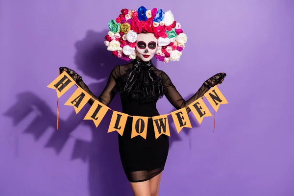 Foto van dode katrina bruid gezicht print cultuur traditionele vakantie hold halloween woord vlaggen opknoping muur slinger bloemen roos hoofdband dragen zwart kostuum geïsoleerde paarse kleur achtergrond — Stockfoto