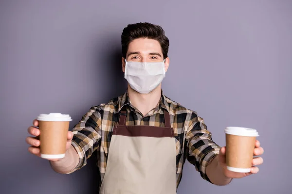 Retrato de sua ele atraente cara saudável barista usando máscara de segurança dando tirar xícara de bebida expresso parar infecção influenza contaminação medidas preventivas isolado fundo cor cinza — Fotografia de Stock