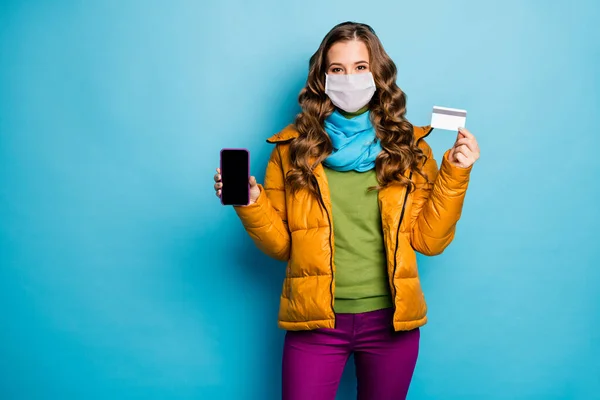 Retrato dela ela agradável muito saudável de cabelos ondulados senhora segurar telefone cartão de plástico aconselhando pagamento passe pagamento preço de venda vestindo máscara de segurança distância social remoto isolado azul cor de fundo — Fotografia de Stock