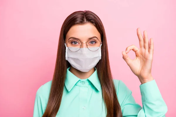 Close-up portret jej ona ładne atrakcyjne dość zdrowe prostowłosa dziewczyna noszenie maski bezpieczeństwa pokazując ok-znak opieki zdrowotnej infekcji grypy odzyskiwania izolowane różowy kolor tła — Zdjęcie stockowe