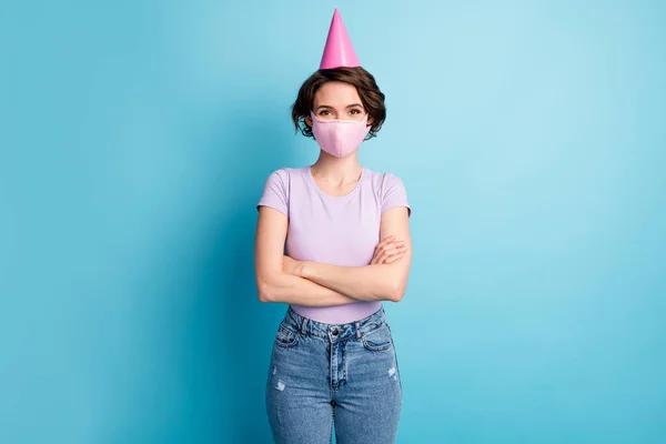 Foto positiver fröhlicher Mädchen Kreuzhände genießen feiern Geburtstag festliche Gelegenheit zu Hause tragen medizinische Maske Zapfen violett lila T-Shirt Jeans isoliert blaue Farbe Hintergrund — Stockfoto