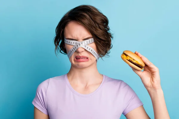 Close up fotó frusztrált lány akar lenni karcsú elutasítása undor hamburger szoros fedél szem centiméter kopás stílus divatos ruhák elszigetelt kék szín háttér — Stock Fotó