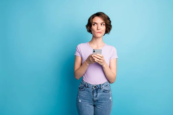 Foto de adicto a la mente insegura bloguero de la red social chica uso del teléfono celular mirada copyspace uso smartphone pensar pensamientos decidir comentarios usar ropa lila aislado color azul fondo — Foto de Stock