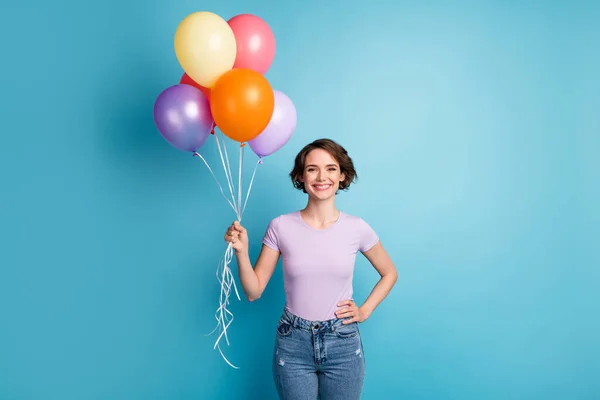 Ritratto di candida ragazza contenuto tenere molti palloncini d'aria godere di festa indossare abiti stile casual isolato su sfondo di colore blu — Foto Stock