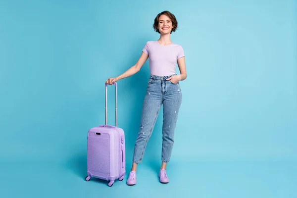 Foto de tamaño completo de chica positiva disfrutar de viaje de bajo costo bodega maleta equipaje desgaste buena mirada ropa gumshoes aislado sobre fondo de color azul —  Fotos de Stock