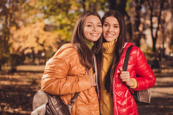 Foto de duas pessoas meninas amigos gostam de viajar cidade natureza campo centro abraço abraço desgaste outerwear segurar saco mochila no outono estação parque — Fotografia de Stock