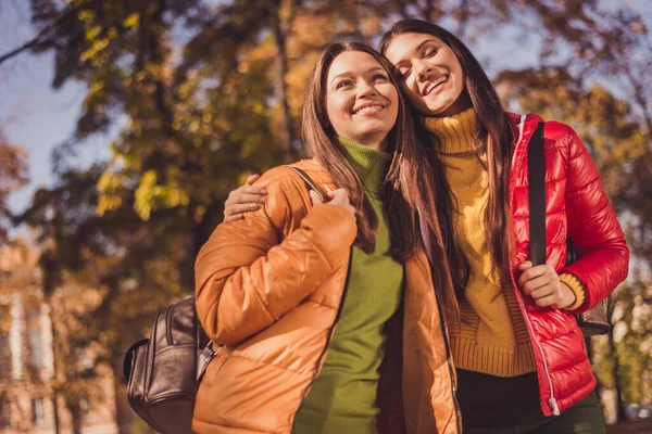 Foto av två bästa vänner flickor vila koppla av i centrum promenad höst park kram omfamna njuta av roliga slitage väska ryggsäck säsong kläder — Stockfoto