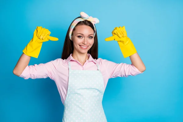 Portret van positief schoner meisje wijzen zelf duim vinger aanraden keuze beslissing oplossing dragen roze shirt geel latex handschoenen hoofdband geïsoleerd over blauwe kleur achtergrond — Stockfoto