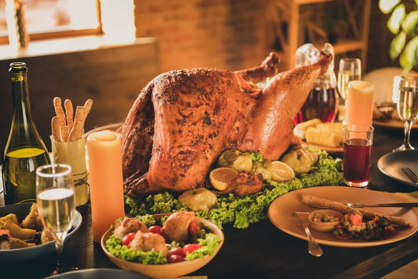 Foto de cerca de grandes asado crujiente relleno de lechuga de pavo empapado decoración de manzana adornar grissini vino espumoso vasos de botella descorchados dos velas en la sala de estar sin personas en el interior — Foto de Stock