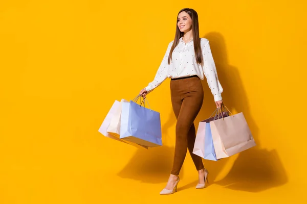 Teljes méretű profil oldalán fotó pozitív vidám lány van bevásárló hétvége megy sétálni tartani sok táska hordanak nadrágot fehér blúz elszigetelt felett ragyog színes háttér — Stock Fotó