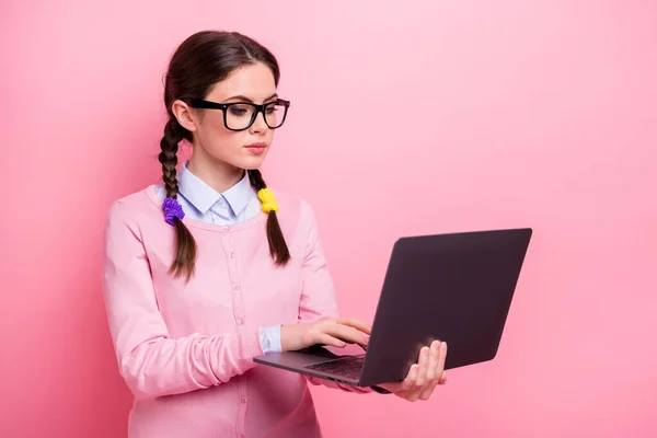 Närbild porträtt av henne hon trevlig attraktiv ganska fokuserad brainy brunhårig tonåring flicka håller i handen laptop skriva det projekt start-up e-banking isolerad på rosa pastell färg bakgrund — Stockfoto