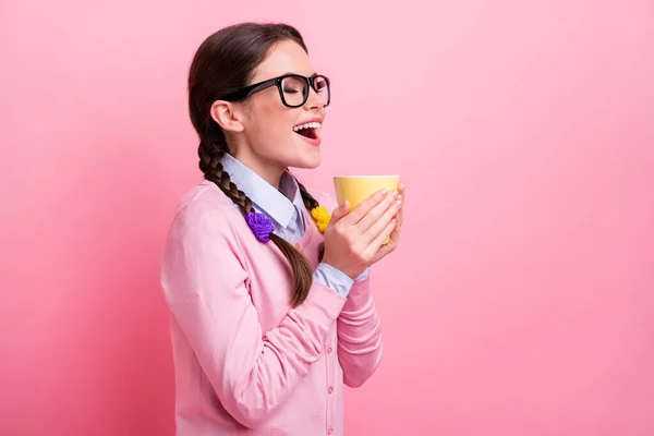 Foto de perfil de la señora estudiante bonita cogida de la mano caliente bebida fresca taza ojos cerrados poco descanso tarea muy alegre buen humor desgaste camisa jersey especificaciones aislado pastel rosa color fondo — Foto de Stock