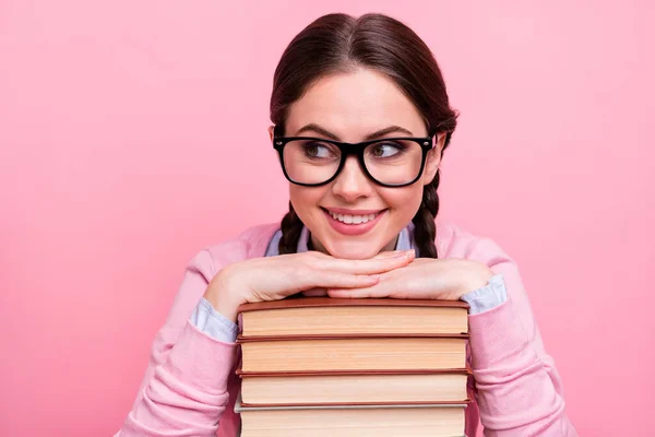 Foto de primer plano de la señora estudiante bastante inclinadas manos cabeza libros pila alumno diligente aficionado a la lectura mira interesado lado desgaste camisa jersey especificaciones aislado pastel color rosa fondo —  Fotos de Stock