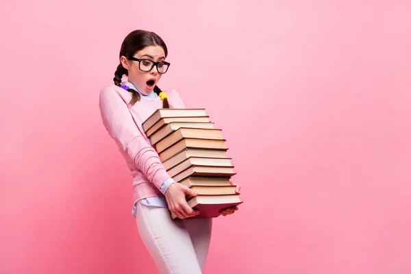 Φωτογραφία προφίλ του υπερφορτωμένο όμορφη μαθήτρια κυρία κατέχουν βαριά βιβλία στοίβα προετοιμάσει εξετάσεις κολέγιο μεγάλη βιβλιοθήκη σπίτι φέρει κουρασμένος φορούν πουκάμισο specs παντελόνι απομονωμένο ροζ χρώμα φόντο — Φωτογραφία Αρχείου