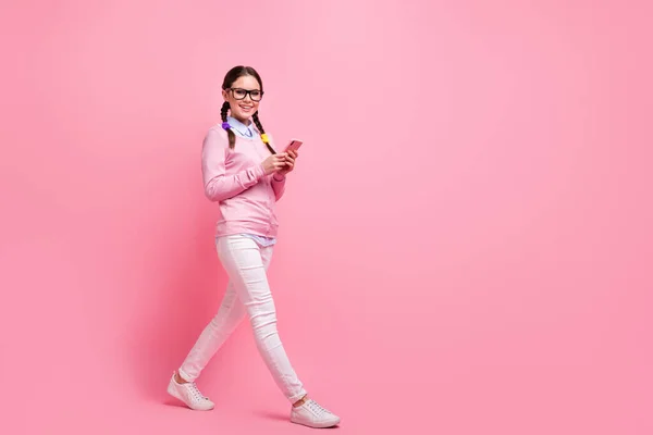 Full längd kroppsstorlek bild av henne hon attraktiv vackra ganska glad glad glad flicka nörd promenader med hjälp av digital enhet 5g app inlägg kommentar feedback isolerad över rosa pastell färg bakgrund — Stockfoto