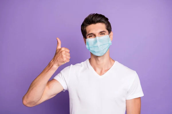 그의 매력적 인 건강 한 남자를 클로즈업 사진 안전 거즈를 쓰고 있는 그는 독감 예방 조치를 보여 주고 있으며 밝고 선명 한 밝은 선명 한 보라색 보라색 배경을 가지고 있다. — 스톡 사진