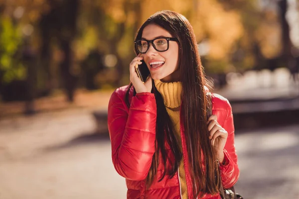 Foto av positiva glada flicka turist njuta resa falla park centrum samtal vän smartphone berätta turné nyheter bära oktober ytterkläder — Stockfoto