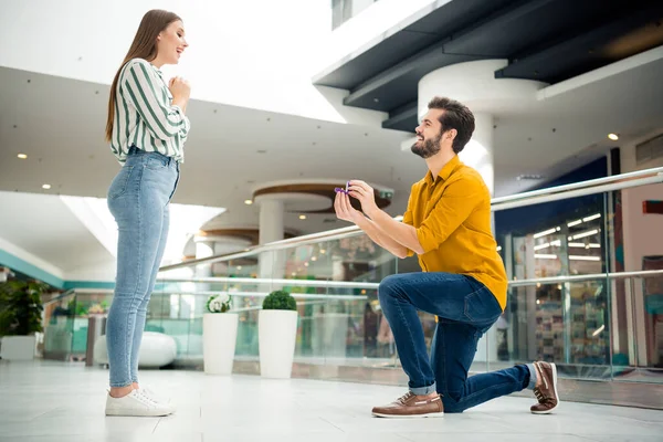 Wil je met me trouwen volledige profiel zijkant foto van twee mensen man knielen aanzoek romantiek verbaasd geschokt meisje geven haar sieraden ring in winkelcentrum — Stockfoto