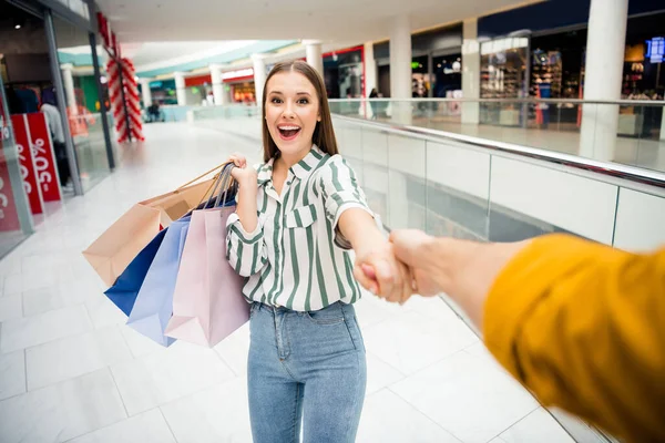 Pov first person point view portrait of her she nice attractive positive cheerful cheery girl holding in hands bags having fun walking having fun leading guy choose choice retail store