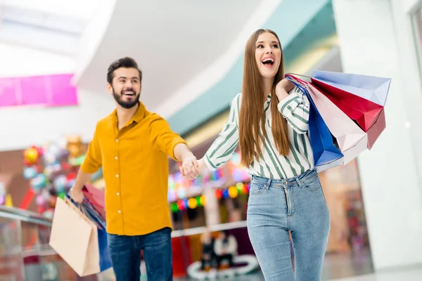 Portret van hem hij haar ze mooie aantrekkelijke modieuze vrolijke vrolijke paar beste vrienden lopen met nieuwe brandy kleding bezoek winkel outlet hebben plezier binnen — Stockfoto