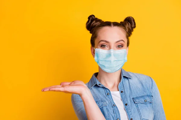 Close-up portret van haar ze aantrekkelijk vrij gezond bruin-harig meisje dragen veiligheidsgaas masker met handpalm kopie ruimte infectie preventie concept geïsoleerd helder levendige gele kleur achtergrond — Stockfoto